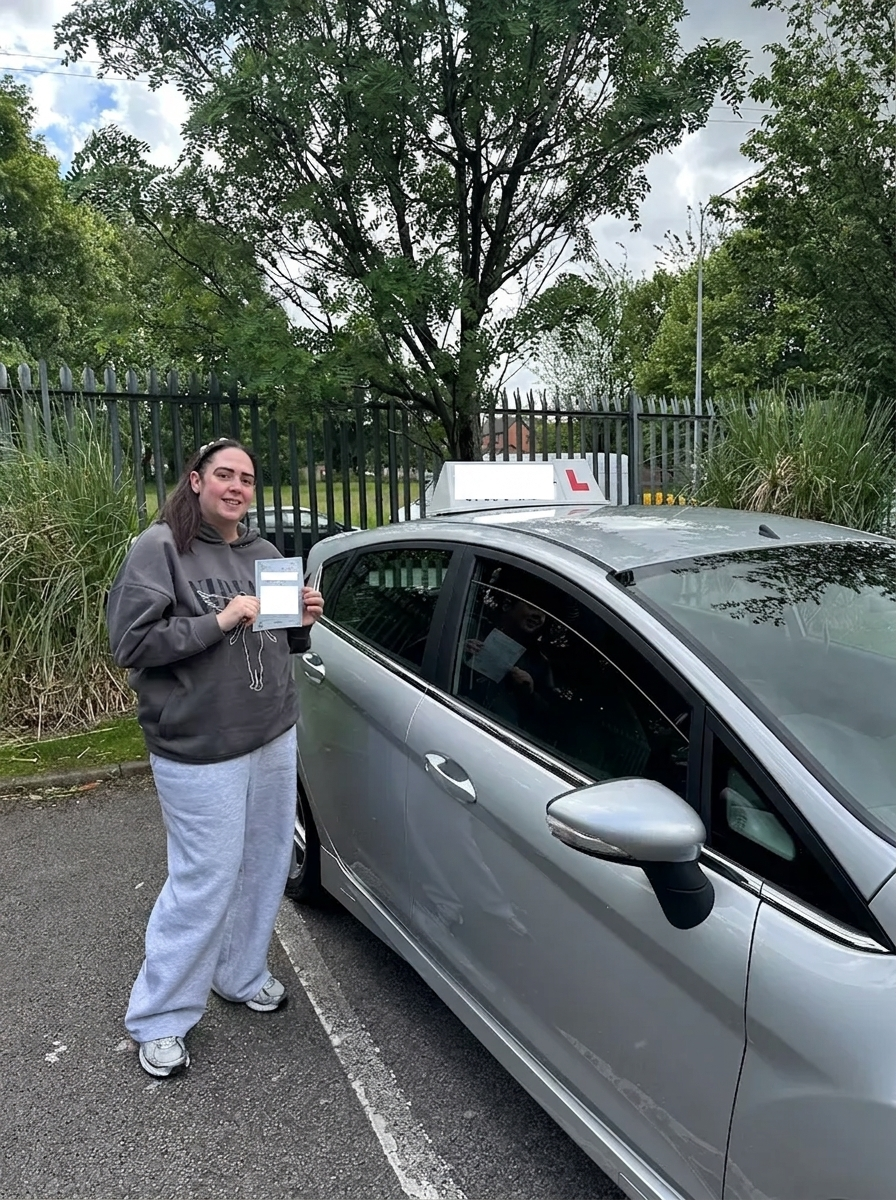 A learner with their pass certificate at the test centre