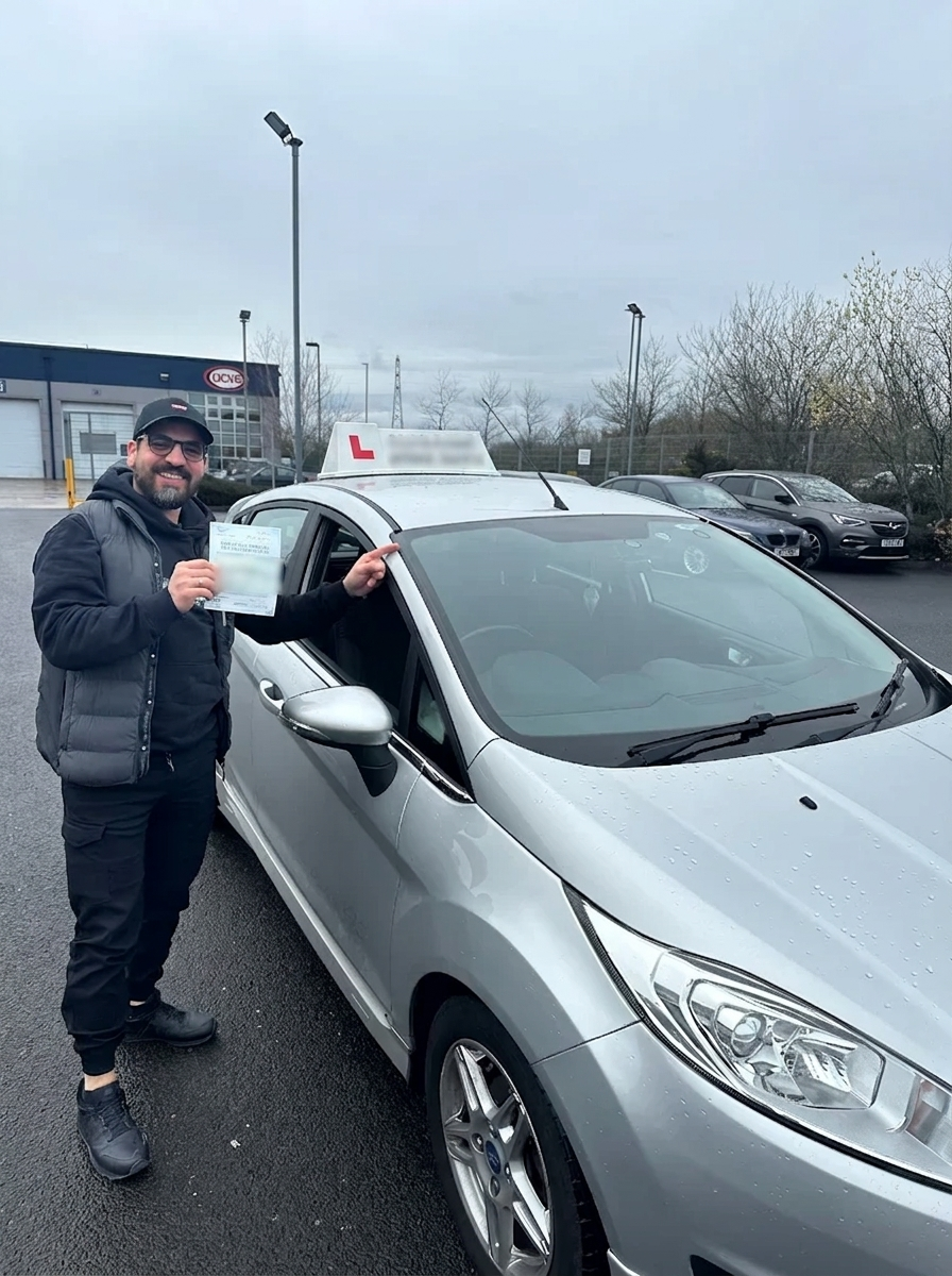 A learner holding their pass certificate by the car