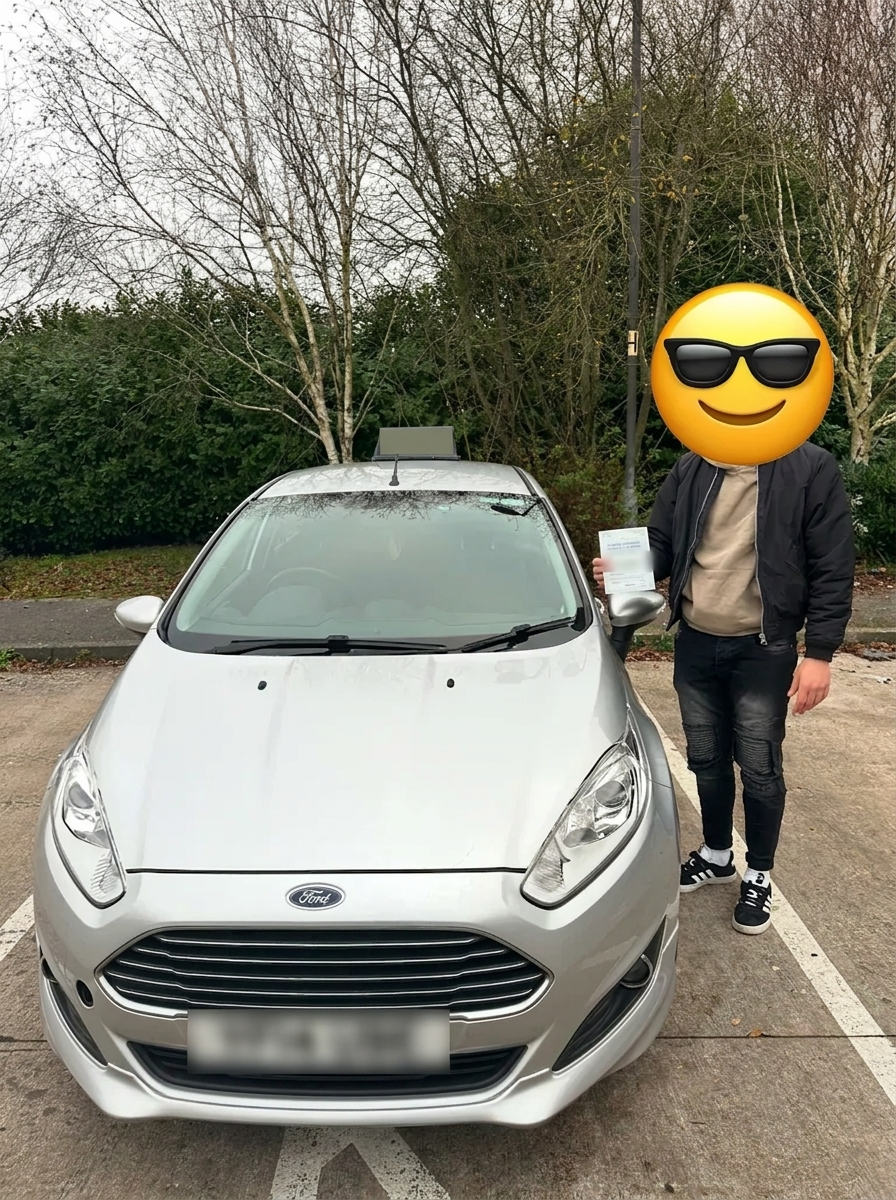 A learner holding their pass certificate beside the car