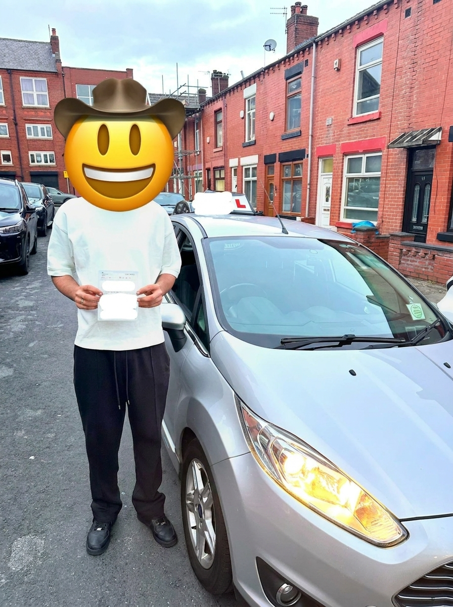 A learner holding their pass certificate beside the car
