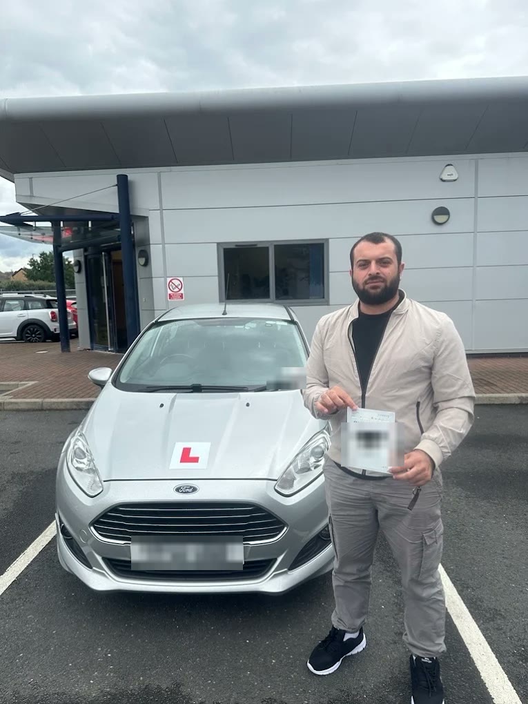 A learner with their pass certificate in front of the Fiesta
